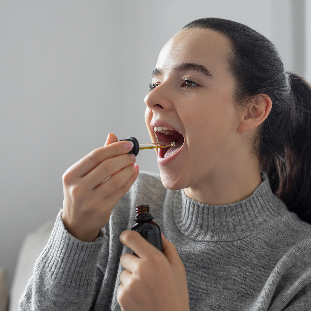 woman using a tincture cbd oil in her mouth